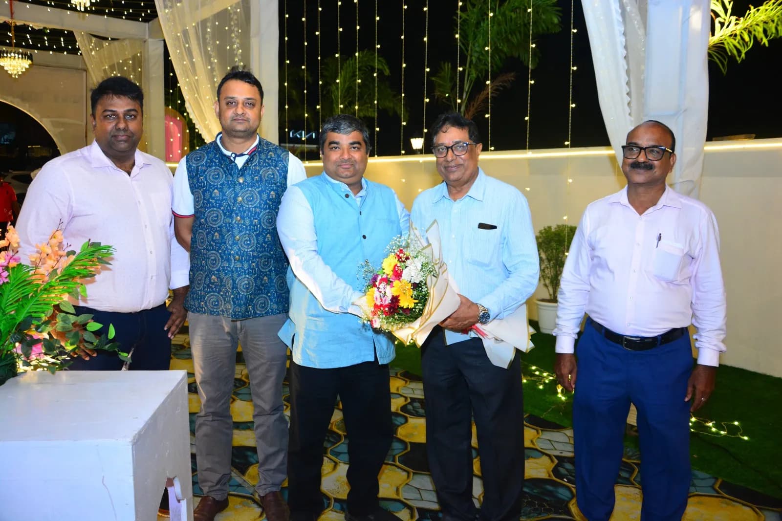 Guests presenting a bouquet to the proprietor at the Golden Jubilee celebration